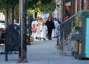 Marietta Torres guía a sus ahijados por Racine Ave., como parte de la ruta de procesión de los parroquianos de San Procopio por el barrio de Pilsen, en apoyo a los inmigrantes del barrio el 26 de octubre. Fotos: Karen Callaway/Católico