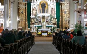 El diácono Rafael Yáñez deposita la hostia en el tabernáculo durante la misa en San Procopio el 26 de octubre . En esa ocasión, los parroquianos participaron en la procesión por las calles de Pilsen.