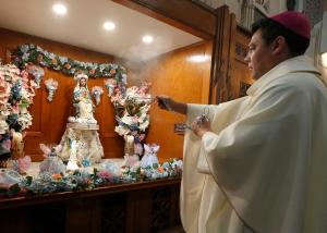 El obispo José Maldonado inciensa la efigie de la Divina Providencia antes de la misa el 14 de noviembre.