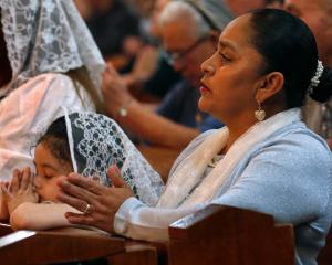 Rosalina Rodriguez y su hija oran durante la oración eucarística.