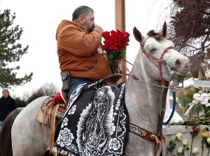 Un jinete se persigna al acercarse a la imagen de la Virgen durante la cabalgata del 6 de diciembre en Des Plaines, convocada por el Club Vaqueros Unidos.